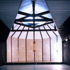 南エントランスから祭壇を見る。徐々に開く天井から１６角形の祭壇空間にすすむ。約８mのスパンはトラスパリによって確保。１６角形の半円空間はスティール半円梁で登り梁を受けながら確保している。